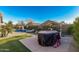 Spacious backyard features a pool, spa, artificial turf, and covered grill, ideal for outdoor enjoyment at 17793 W Corrine Dr, Surprise, AZ 85388