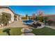 Landscaped backyard featuring a sparkling pool, spa, artificial turf, and seating for relaxation at 17793 W Corrine Dr, Surprise, AZ 85388