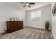 Bedroom featuring neutral carpet, light-filled window and wood accents at 17793 W Corrine Dr, Surprise, AZ 85388