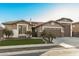 Inviting single-story home featuring a well-manicured lawn, desert landscaping, and attached three-car garage at 17793 W Corrine Dr, Surprise, AZ 85388