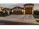 Inviting single-story home featuring a well-manicured lawn, desert landscaping, and attached three-car garage at 17793 W Corrine Dr, Surprise, AZ 85388