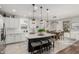 Well-lit kitchen with white cabinets, marble counters, island with seating, and modern pendant lighting at 17793 W Corrine Dr, Surprise, AZ 85388