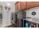 A convenient laundry room featuring modern washer and dryer with countertops and ample storage at 17793 W Corrine Dr, Surprise, AZ 85388