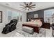 Main bedroom with a gray accent wall, king bed, massage chair, and shuttered windows at 17793 W Corrine Dr, Surprise, AZ 85388