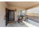 Cozy front porch with rocking chairs, a welcome mat, and a charming exterior light fixture at 18118 W Golden Ln, Waddell, AZ 85355