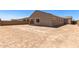 Rear view of the home with a covered patio and a backyard enclosed by a block fence at 18192 W Ashley Dr, Goodyear, AZ 85338