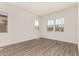 Bright, airy bedroom with wood-look floors and multiple windows, creating a peaceful retreat for relaxation and rest at 18192 W Ashley Dr, Goodyear, AZ 85338