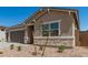 A cozy single-story home with a stone veneer, xeriscaping, and mature vegetation at 18192 W Ashley Dr, Goodyear, AZ 85338