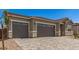 Attractive home showcasing a three-car garage, desert landscaping, and a spacious driveway at 18192 W Ashley Dr, Goodyear, AZ 85338