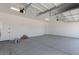 Spacious two-car garage with clean walls, painted floor, and modern garage door openers at 18192 W Ashley Dr, Goodyear, AZ 85338