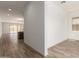 Hallway offers a view into the open floorplan showcasing the kitchen and living room, seamlessly blending for modern living at 18192 W Ashley Dr, Goodyear, AZ 85338