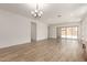 Spacious living area with wood-look tile flooring and a modern chandelier at 18192 W Ashley Dr, Goodyear, AZ 85338