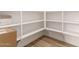 Well-organized walk-in pantry with ample shelving for convenient storage and stylish wood-look flooring at 18192 W Ashley Dr, Goodyear, AZ 85338