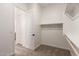 Bright walk-in closet featuring carpet floors and several shelves for ample storage space at 18192 W Ashley Dr, Goodyear, AZ 85338