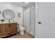 Bright bathroom features a modern vanity, round mirror, and shower with stylish tile at 2041 W Palo Verde Dr, Phoenix, AZ 85015