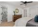 This primary bedroom has a ceiling fan and a wooden dresser with gold circular mirror at 2041 W Palo Verde Dr, Phoenix, AZ 85015