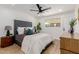 Bright bedroom featuring a plush gray upholstered bed frame, stylish ceiling fan, and hardwood floors at 2041 W Palo Verde Dr, Phoenix, AZ 85015