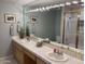 Bright bathroom featuring double sinks, large mirror with vanity lights, and a tiled shower with glass doors at 2251 N 32Nd St # 21, Mesa, AZ 85213