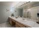 Elegant bathroom featuring a double vanity, a large mirror with stylish lighting, and a walk-in shower at 2251 N 32Nd St # 21, Mesa, AZ 85213