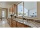 Well-lit kitchen featuring granite countertops, wooden cabinetry, and a view to the pool area at 2251 N 32Nd St # 21, Mesa, AZ 85213