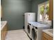 Laundry room featuring front loading washer and dryer, wood cabinets, and a window offering natural light at 2251 N 32Nd St # 21, Mesa, AZ 85213