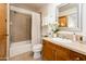 Bathroom with shower and tub, tiled backsplash and light wooden vanity at 231 W Portland St, Phoenix, AZ 85003