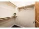 Walk-in closet with black patterned carpet, wooden dowel racks, and white shelving at 231 W Portland St, Phoenix, AZ 85003