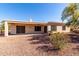 Charming back exterior with covered patio, desert landscaping, and neutral paint palette create a welcoming space at 23116 N Padaro Ct, Sun City West, AZ 85375