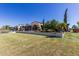 Expansive backyard featuring a lush lawn, covered patio, and manicured landscaping at 23116 N Padaro Ct, Sun City West, AZ 85375