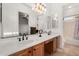 Spacious bathroom with double sinks, wood cabinets, a large mirror and stylish light fixtures at 23116 N Padaro Ct, Sun City West, AZ 85375