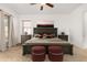 This staged bedroom features carpet, ceiling fan, large bed, and natural light from the window at 23116 N Padaro Ct, Sun City West, AZ 85375