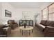 Cozy living room featuring stylish brown leather furniture and neutral decor for a relaxing atmosphere at 23116 N Padaro Ct, Sun City West, AZ 85375