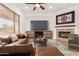 Staged living room with a fireplace and mounted TV at 23116 N Padaro Ct, Sun City West, AZ 85375