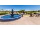 Decorative fountain overlooks serene golf course, framed with lush greenery and a bright blue sky at 23116 N Padaro Ct, Sun City West, AZ 85375