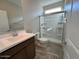 Clean bathroom featuring a vanity, a large mirror, and a glass-enclosed shower with built-in shelving at 23229 W Florence Ave, Buckeye, AZ 85326