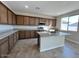 Modern kitchen with granite countertops, stainless steel appliances, and a center island with a sink at 23229 W Florence Ave, Buckeye, AZ 85326