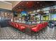 Stylish bar area with a dark wood bar top, red stools, patterned floors, and multiple televisions at 23731 S Angora Dr, Sun Lakes, AZ 85248