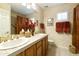 Elegant bathroom featuring double sinks, a large mirror, and a tiled shower with glass door at 23731 S Angora Dr, Sun Lakes, AZ 85248