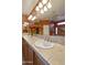 Bathroom with dual sinks, tile countertop and backsplash, and decorative lighting with ceiling fan at 23731 S Angora Dr, Sun Lakes, AZ 85248