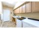 Laundry room featuring tile floors, sink, upper cabinets, with washer and dryer. Door to the exterior at 23731 S Angora Dr, Sun Lakes, AZ 85248