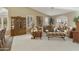 Inviting living room featuring plush carpeting, large windows, comfortable seating, and a decorative china cabinet at 23731 S Angora Dr, Sun Lakes, AZ 85248