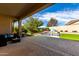 A covered patio leads to a tranquil pool with a rock waterfall feature and a small lawn at 2422 W Aloe Vera Dr, Phoenix, AZ 85085