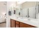 Well-lit bathroom with double sinks, a large mirror, and wood-tone cabinets at 2422 W Aloe Vera Dr, Phoenix, AZ 85085