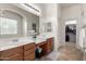 Well-lit bathroom features double sinks, arched mirrors, and tile floors at 2422 W Aloe Vera Dr, Phoenix, AZ 85085