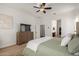 Bright main bedroom with ceiling fan, wooden dresser, and ensuite bathroom at 2422 W Aloe Vera Dr, Phoenix, AZ 85085