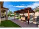 Well-equipped outdoor kitchen with grill and bar, overlooking a refreshing pool area and green lawn at 2422 W Aloe Vera Dr, Phoenix, AZ 85085