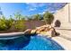 Beautiful pool featuring a natural rock waterfall for a serene and luxurious backyard escape at 2422 W Aloe Vera Dr, Phoenix, AZ 85085