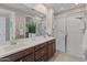 Bathroom with double sink vanity, spacious glass shower, and neutral color palette at 24670 N 171St Ln, Surprise, AZ 85387