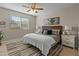 Bright bedroom with neutral décor, a ceiling fan, and a comfortable-looking bed at 24670 N 171St Ln, Surprise, AZ 85387