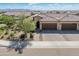 Aerial view of a beautiful home featuring a well-manicured yard, mature trees, and a spacious three-car garage at 24670 N 171St Ln, Surprise, AZ 85387